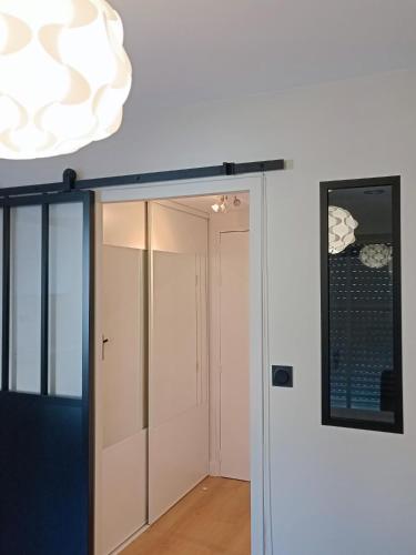 un couloir avec une porte en verre et un miroir dans l'établissement Studio Kleber, à Nantes