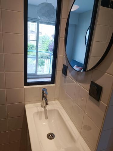 une salle de bain avec un lavabo et un miroir dans l'établissement Studio Kleber, à Nantes