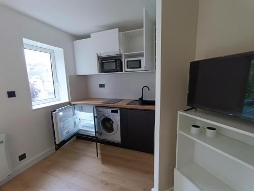 une cuisine avec un lave-linge et un micro-ondes dans l'établissement Studio Kleber, à Nantes