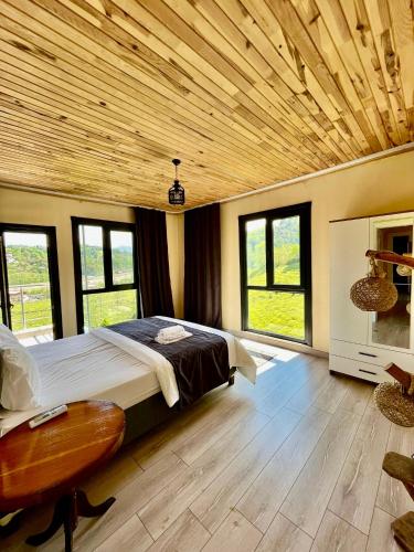 a bedroom with a large bed with a wooden ceiling at Noğa Suit Apart in Pazar