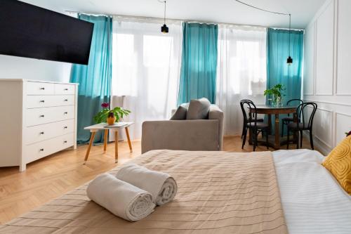 a bedroom with a bed and a living room at Apartament Różowy Jeleń in Gliwice
