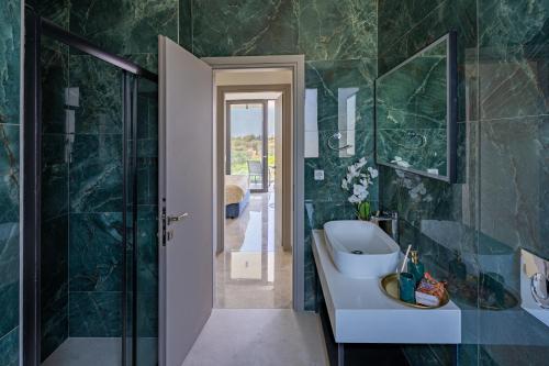 Un baño con lavabo, inodoro y espejo. en Villa Pasadra, en Afantou