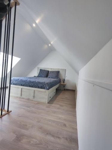 une chambre avec un lit dans un grenier dans l'établissement Studio neuf situé au cœur d'un bourg paisible, à Pacé