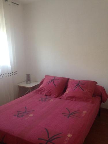 - un lit avec une couette rose dans une chambre dans l'établissement Location t2 vue magnifique sur la baie de La Ciotat, à La Ciotat