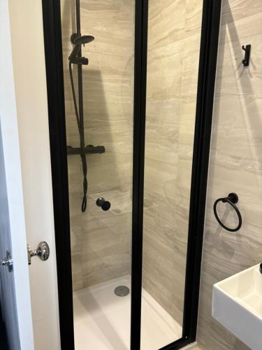 a shower with a glass door in a bathroom at Goldie's Retreat in Blackrod