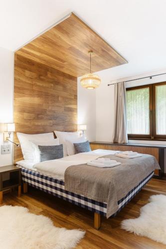 a bedroom with a large bed with a wooden headboard at BIO HOTEL & WELLNESS Zlatý Hýľ in Hýľov