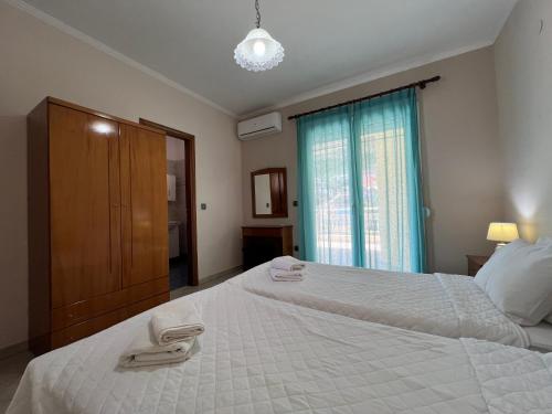 a bedroom with a large white bed and a window at Katerina Seaview Apartment in Chrysi Ammoudia