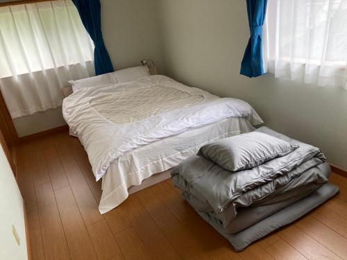 a small bedroom with a bed and a ottoman at 寺田旅館一軒家レンタル素泊まり最大15人宿泊可能 4名様まで同一料金 in Mine