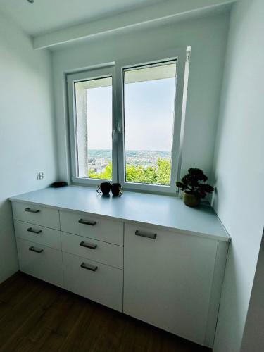 a white dresser with two windows in a room at Cliff Apartment Redłowo in Gdynia