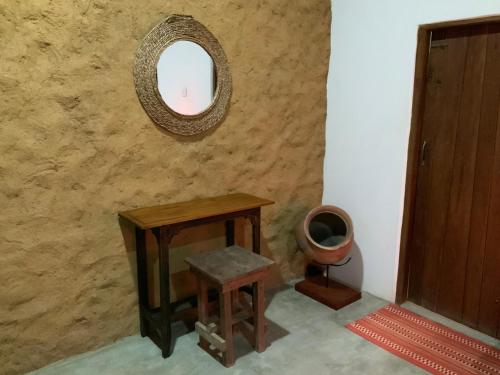 a mirror on a wall with a table and a stool at Wild Wadi Wilpattu - Villas with private Plunge Pools in Wilpattu