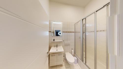 un bagno bianco con wc e doccia di SweetHome - Zentral - Küche & Parkplatz, WiFi a Halle an der Saale