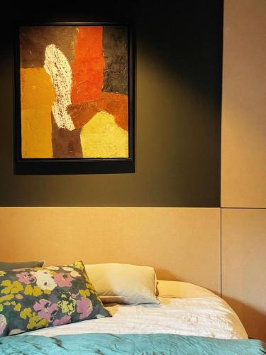 un lit dans une chambre avec un tableau sur le mur dans l'établissement Minimaliste contemporain house - hot tub - sauna, à Blainville-sur-Mer