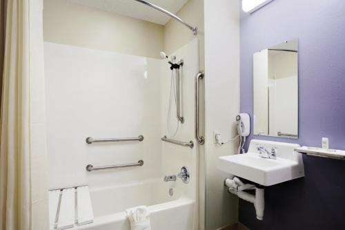 a white bathroom with a sink and a shower at Rincon Inn and Suites in Rincon