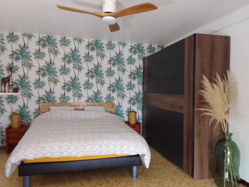 une chambre avec un lit et un ventilateur de plafond dans l'établissement Maison au calme vue mer à 180, à Toulon