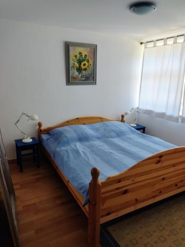 a bedroom with a wooden bed with a blue blanket at Chalet Forsthof Everstorf in Grevesmühlen