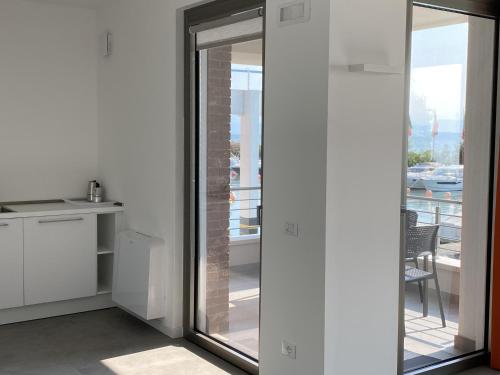 a kitchen with sliding glass doors leading to a balcony at Sirmio Apartments - Darsena Stay in Sirmione