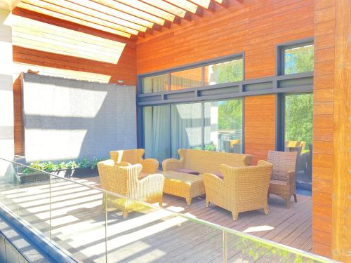 a patio with chairs and a table on a deck at Hotel Burabay in Shchūchīnsk