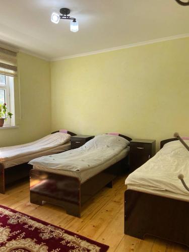 a room with three beds and a rug at Guest House Azaliya, Сары-Челек гостевой дом Азалия in Arkit