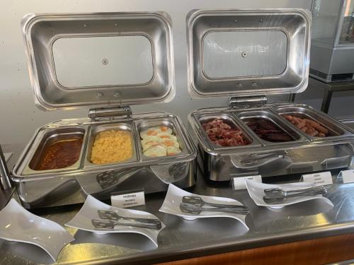 a buffet with several trays of food on a counter at MEANDER THERMAL & SKI REZORT ORAVICE in Oravice