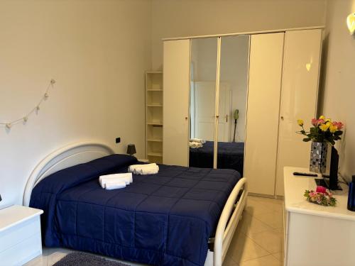 una camera da letto con un letto blu e uno specchio di Casa Roma Arenzano ad Arenzano