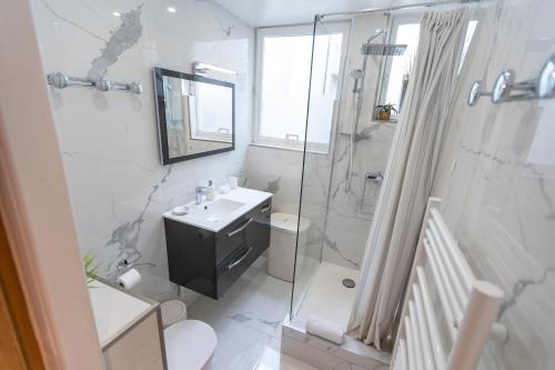 une salle de bain blanche avec un lavabo et une douche dans l'établissement Pompidou 3, Rue Simon le Franc - 4 places, à Paris