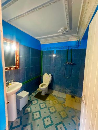 a blue tiled bathroom with a toilet and a sink at Maison d'hôte Riad Todra in Tinerhir