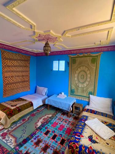 a blue room with two beds and a ceiling at Maison d'hôte Riad Todra in Tinerhir