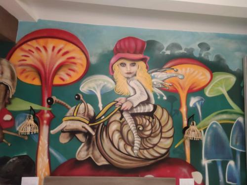 a painting of a woman on a snail on a wall at FamilyHostelPinto in Pinto