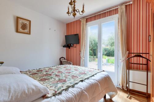 une chambre avec un lit et une porte coulissante en verre dans l'établissement Maison 3 chambres 200m de la mer, à La Pironnière
