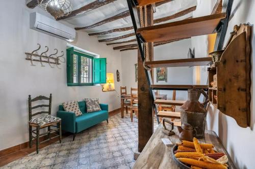 un salon avec un canapé bleu et une table dans l'établissement Ruralya Alojamientos Granada Constitución Square, à Grenade