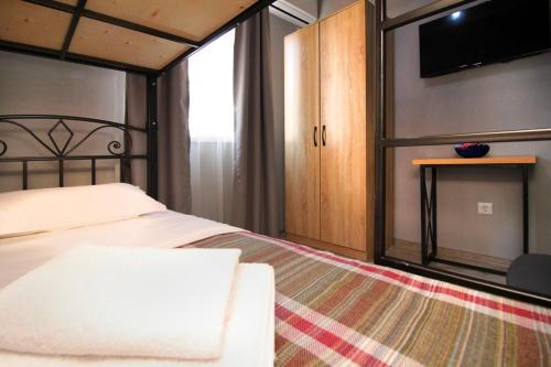 a bedroom with a bed and a tv on the wall at KazNest apart-hotel in Almaty