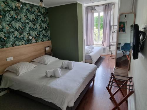 a bedroom with a bed with two towels on it at Hôtel & Restaurant Le Patio VICHY in Vichy