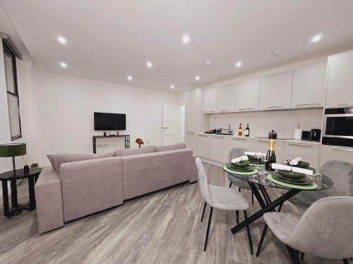 a living room with a couch and a table at Abbey Corner by Nivaas 3-Located in the heart of the city centre-5 minute walk to train station-20 minutes to London via train in Reading