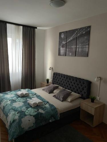 a bedroom with a bed with a blue and green blanket at Apartman Mijailović 2 in Soko Banja