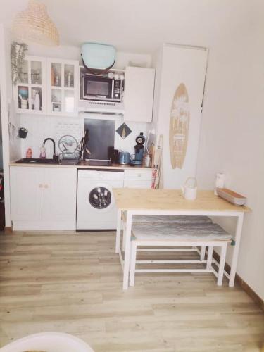 Il comprend une cuisine équipée d'une table, d'un four micro-ondes et d'une cuisinière. dans l'établissement Happy blue house, à Leucate
