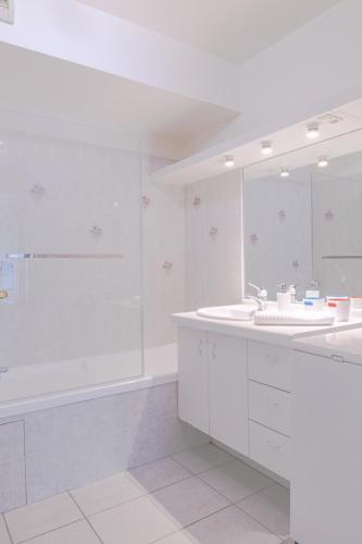 une salle de bain blanche avec une baignoire et un lavabo dans l'établissement Le Gouverneur, 100m du lac avec parking, à Annecy