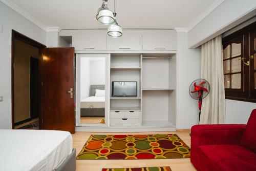 a living room with a red couch and a tv at Elegant Stay in Mohandessin in Cairo