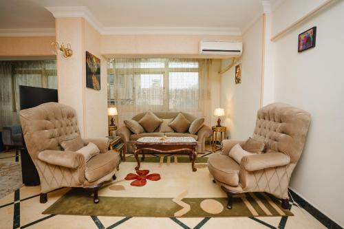 a living room with two chairs and a couch at Elegant Stay in Mohandessin in Cairo