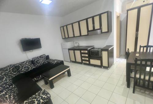 a living room with a bed and a desk with a microwave at Sunrise Hotel Cameria in Durrës