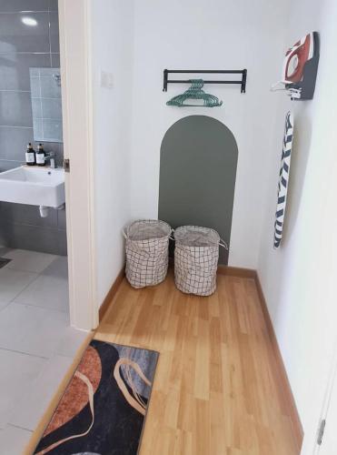 a bathroom with a sink and two baskets on the floor at Imperium Residence House SEAVIEW at Swiss Belhotel in Kuantan