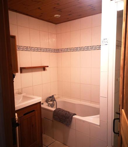 une salle de bain avec une baignoire et un lavabo dans l'établissement Appartement GENEPI 1350, à Saint-Chaffrey