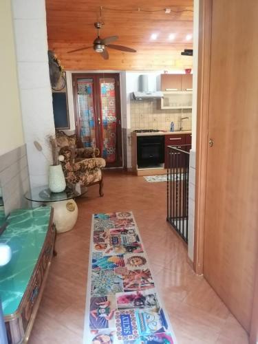a living room with a table and a kitchen at Casa Ruffo in Francavilla di Sicilia