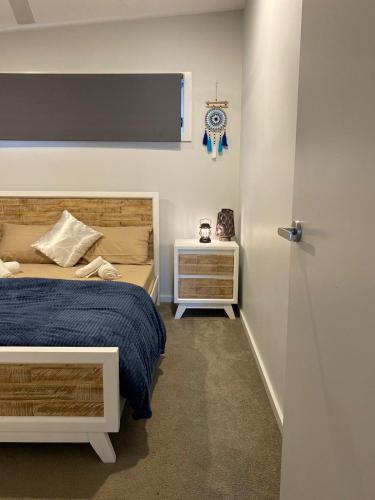 a bedroom with a bed and a clock on the wall at Coastal Hideaway By Lake in Toukley