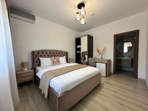 a bedroom with a large bed and a mirror at Vila Bloom in Vama Veche