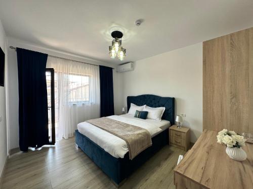a bedroom with a large bed and a table at Vila Bloom in Vama Veche