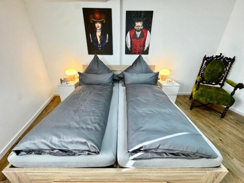 a bed in a room with paintings on the wall at Big-Kurstadtapartment Baden-Baden in Baden-Baden