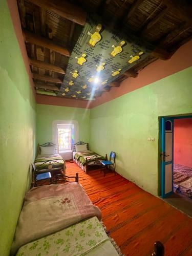 a room with four beds in it with a ceiling at Maison d'hôte Riad Todra in Tinerhir