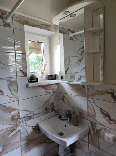 une salle de bains avec un lavabo et un miroir dans l'établissement Dukuri, à Ragaciems