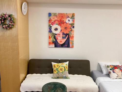 a living room with a couch and a painting on the wall at Gangnam Station Fun House in Seoul