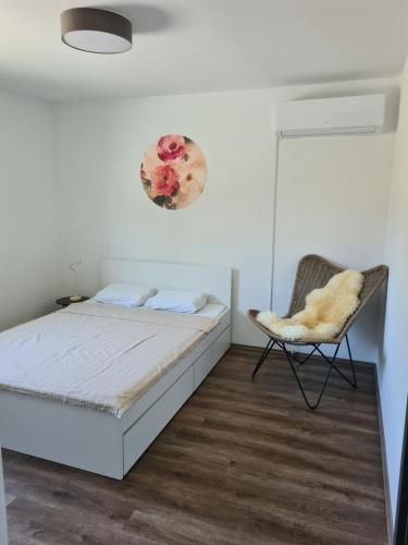 sypialnia z łóżkiem i krzesłem w obiekcie Rooms and apartments Vili w Ptuju